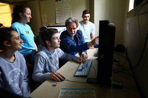 professor instructing students on editing equipment