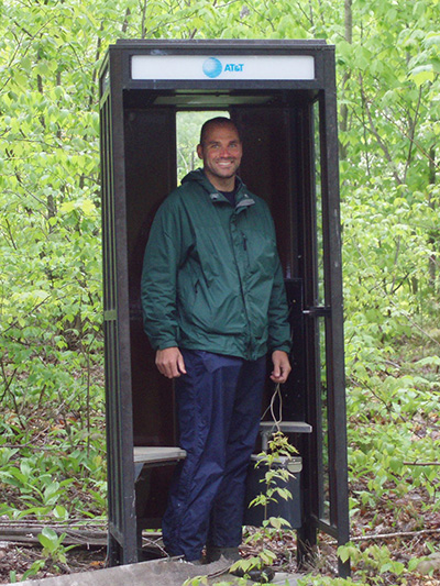 Eric Doucette standing in a phone booth