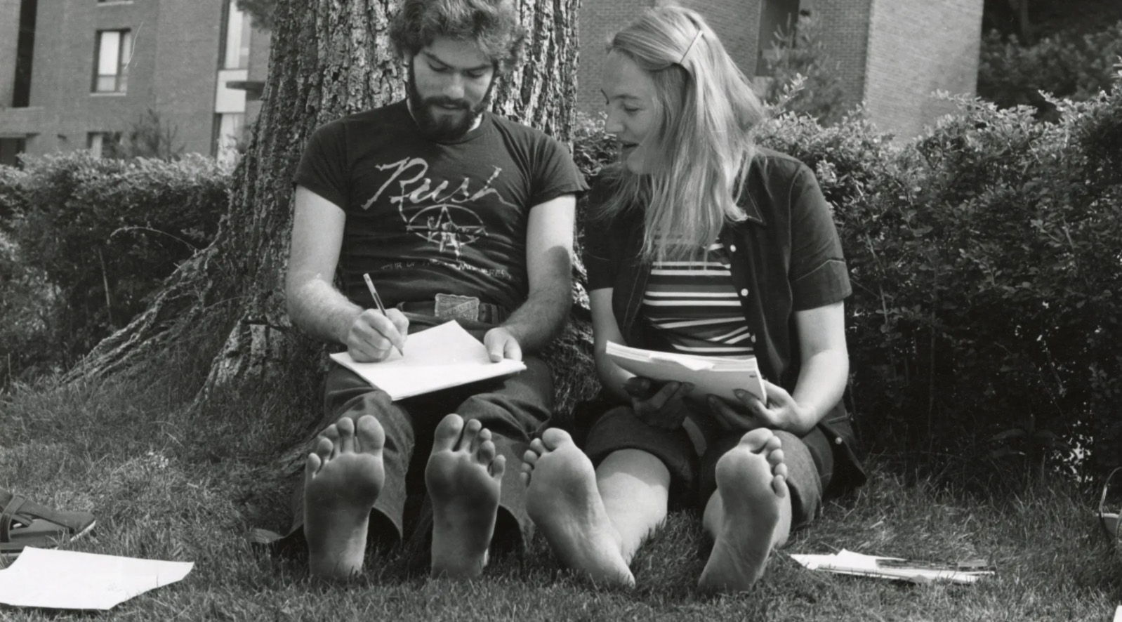 Two students working on a paper on the lawn