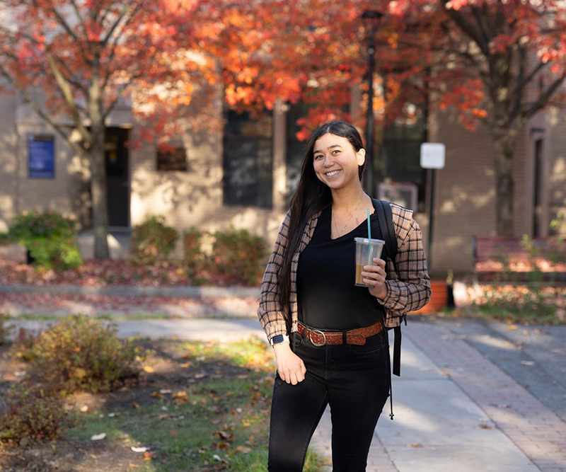 Student on campus among fall foliage